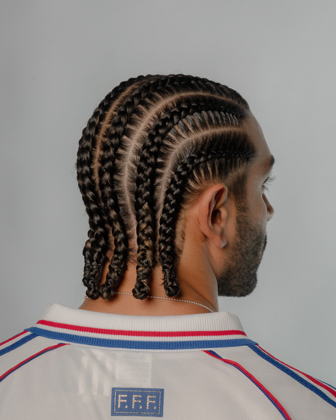 Barber washing men's braided hair and massaging scalp