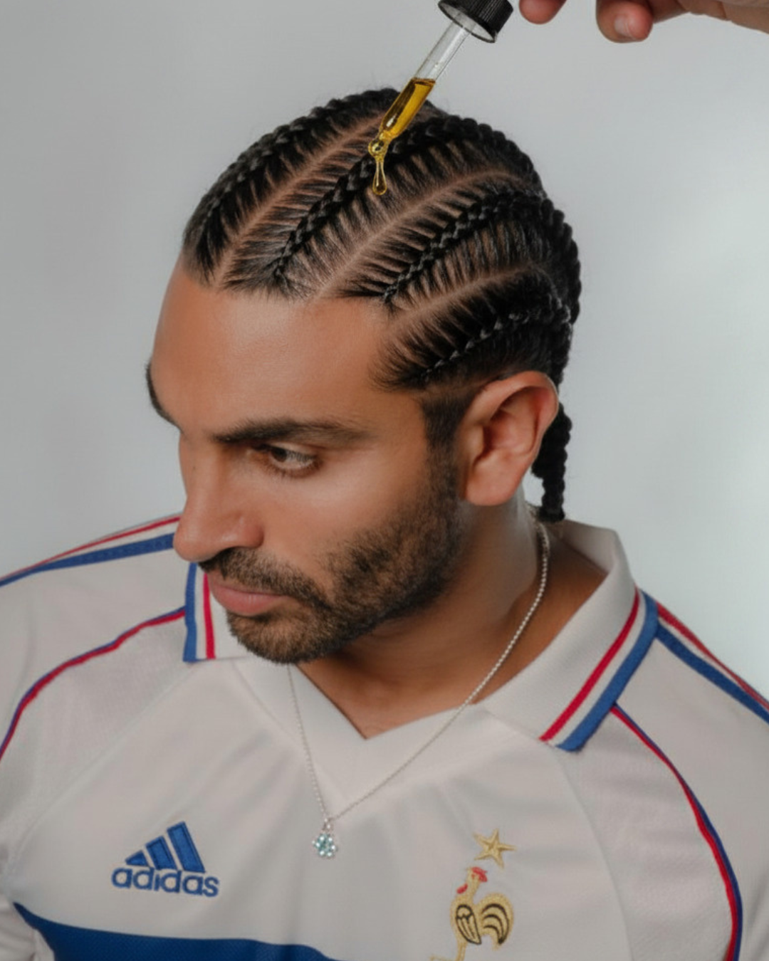 Applying natural moisturizing oils to men's scalp and braids